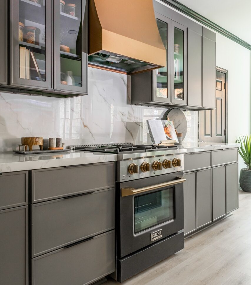 A kitchen with FineLine cabinet fronts in Pewter and a copper range hood