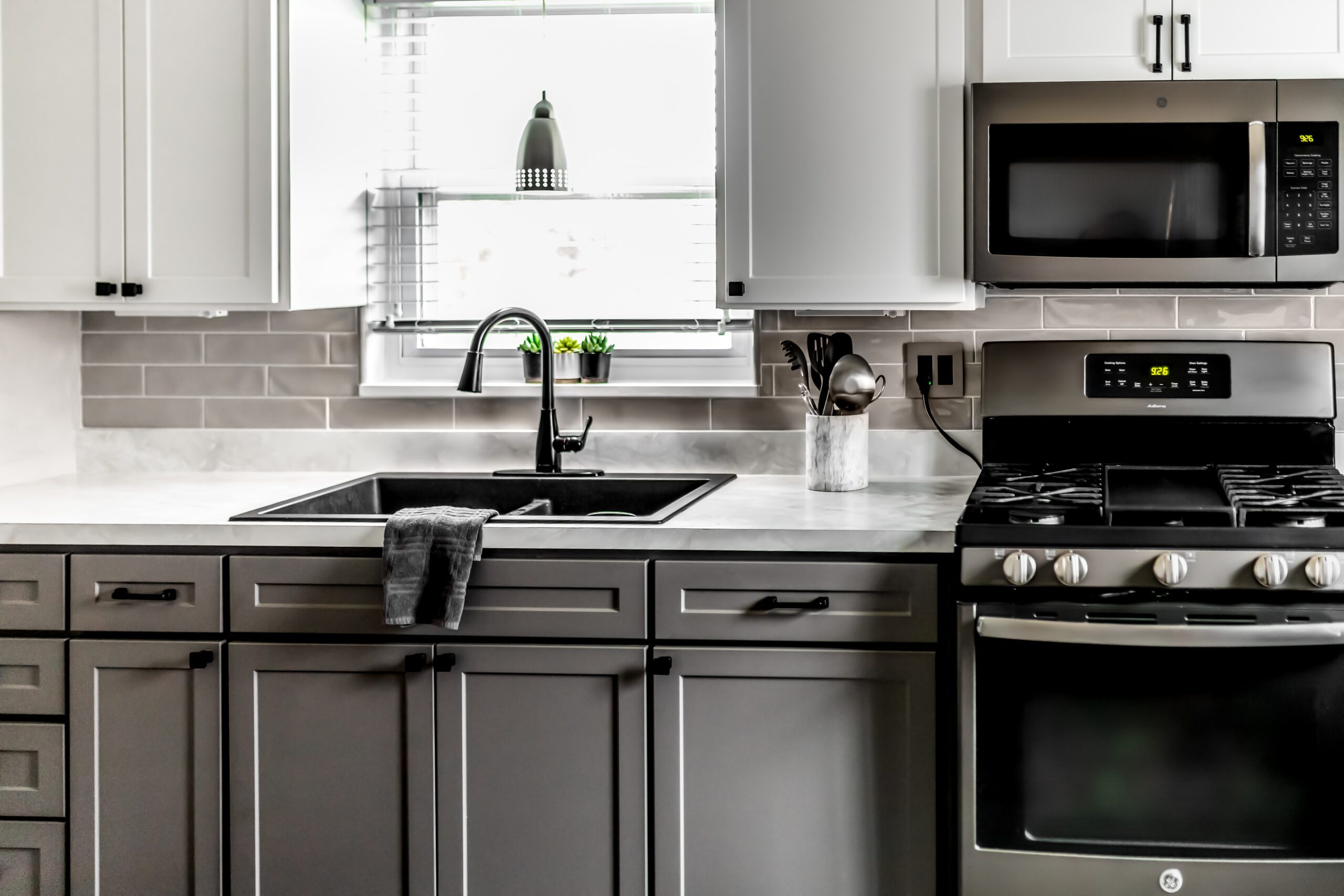 A refaced kitchen with dark gray cabinets and a farmhouse sink