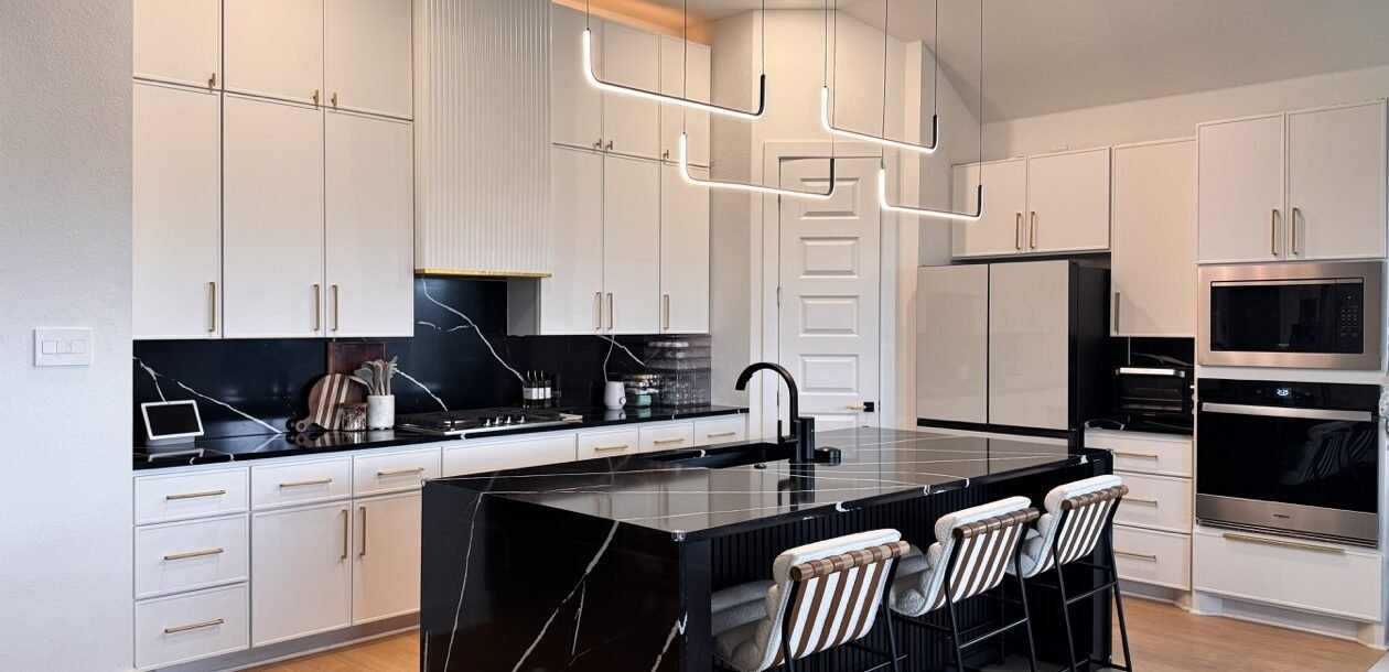 A white refaced kitchen with a black island